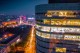 Fațada de sticlă iluminată noaptea și panorama Pieței Victoriei